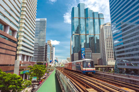 Bangkok - June 9, 2019: a BTS train travels between the downtown 's skyscrapers against the blue...
