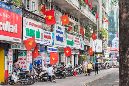 Ho Chi Minh, Vietnam - April 28, 2019: Tran Hung Dao Street decorated with Vietnamese flags on the eve of Reunification Day and International Labor Day. Abundance of flags accompany holidays in Saigonのeditorial素材