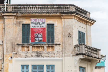 Phnom Penh, Cambodia - January 17, 2019: the top floor of an old house with placard For sale,...