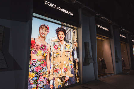 Ho Chi Minh City, Vietnam - April 23, 2019: Dolce & Gabbana shop's exterior at night, front windows with clothes and a poster showing women models and inhabited by alive geckos.のeditorial素材
