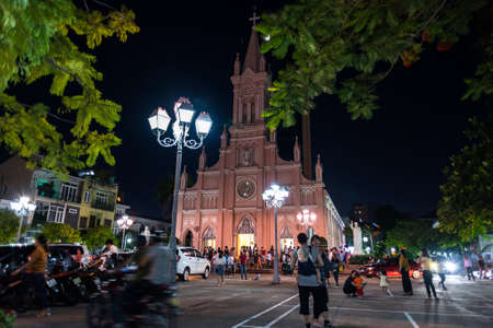 Da Nang, Vietnam - October 21, 2018: Danang Cathedral (Basilica of the Sacred Heart of Jesus Christ) and its yard at night, with people who come to attend at Sunday service.のeditorial素材