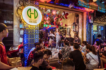 Ho Chi Minh, Vietnam - April 28, 2018: a music band performs surrounded by visitors at Dong Duong Cafe in Bui Vien Street that is famous with its nightlife. The cafe interior is seen from the street.のeditorial素材