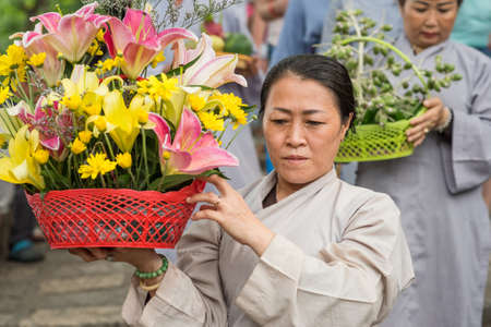 Nha Trang, Vietnam - May 5, 2018: A woman with a basket of flowers in the procession of Po Nagar Temple festival (Le hoi Thap Ba Ponagar). Po Nagar temple is a heritage of Champa and Cham people.のeditorial素材