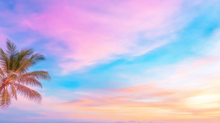 A serene scene featuring a palm tree against a pastel sky. The sky is a blend of pink, blue, and orange hues, creating a dreamy, tranquil atmosphere at sunset.の素材