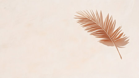 A single, copper-toned palm leaf casts a soft shadow on a textured beige background, creating a minimalist and elegant composition. The lighting is gentle and diffused.の素材
