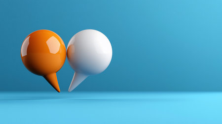 Two glossy speech bubbles, one orange and one white, stand side-by-side against a blue background. The composition is clean and modern, emphasizing communication and dialogue.の素材
