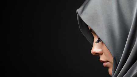 Profile view of a woman wearing a gray hijab, focusing on her face, eyelashes, and the texture of the fabric.の素材