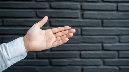 A human hand, palm facing upwards, is extended. The skin is light-toned, and a white shirt sleeve is visible. The hand is open and relaxed.の素材