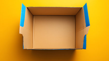 An open cardboard box with blue edges, viewed from above. The box is empty, showing the interior. The cardboard has a textured surface.の素材