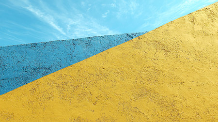 Rough textured wall surface, diagonally divided into vibrant blue and warm yellow sections. Coarse stucco-like material.の素材