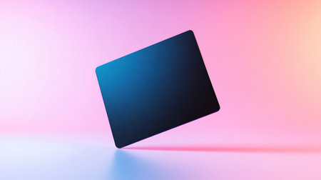 A modern, minimalist dark laptop hovers diagonally against a soft, colorful gradient background, creating a sense of innovation and digital elegance.の素材