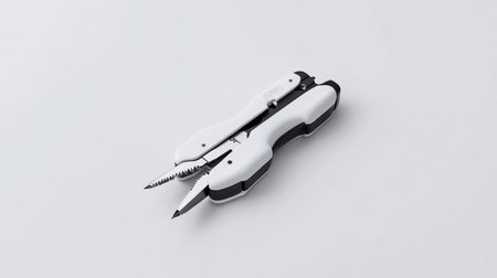 A close-up shot of a white and black multi-tool on a white surface.の素材