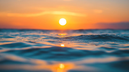 A beautiful sunset over the ocean, with the sun reflecting on the waters surface.の素材