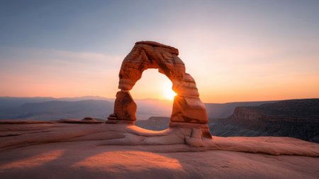 Stunning photograph of Delicate Arch at sunset, showcasing the iconic sandstone formation against a vibrant sky. Located in Arches National Park, Utah.の素材