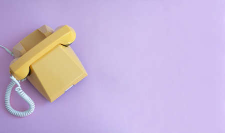 Yellow retro phone on a pink background.の写真素材