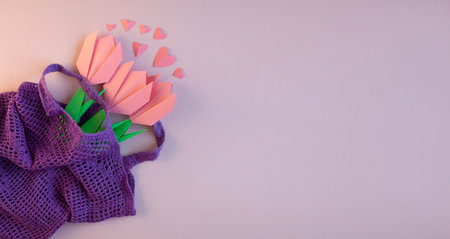 Paper pink tulips in a purple eco bag on a pink background. Spring decor. the concept of ecology, a...