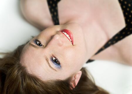 Portrait of Beautiful Smiling Woman Lying Upside Downの写真素材