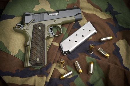 45 Firearm Pistol Clip And Hand Gun Ammunition on military camouflage backgroundの写真素材