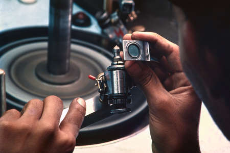 Diamond cutting machine cutting diamonds against a spinning plate. Diamond workshop in Surat City,...
