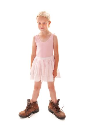 Young blonde girl dressing up in ballet outfit and Dad's big walking bootsの写真素材