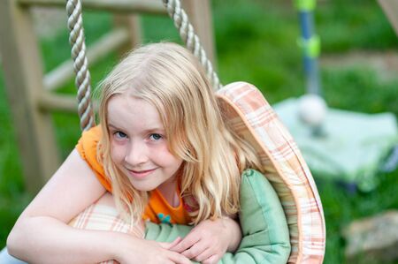 Headshot of pretty young blonde girl making eye contact and smilingの写真素材
