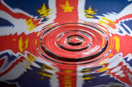 UK Union Jack with the Stars of the European Union reflected in the ripples of a water splash. Abstract Brexit background.の写真素材