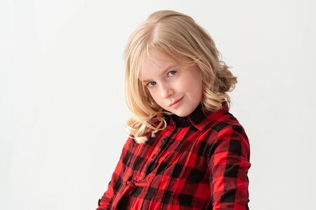 Medium shot of a beautiful young blonde preteen girl with attitude on a white studio background