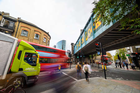 LONDON - SEPTEMBER 30, 2019: Long exposure of the famous Camden Lock sign painted on the bridge across Camden High Street with blurred red London Double Decker buses approaching, along with other traffic and pedestriansのeditorial素材