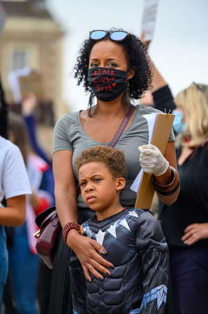 Richmond, North Yorkshire, UK - June 14, 2020: A strong female leader wears a Black Lives Matter PPE face mask and hugs her Superhero son at a BLM protest in Richmond, North Yorkshireのeditorial素材
