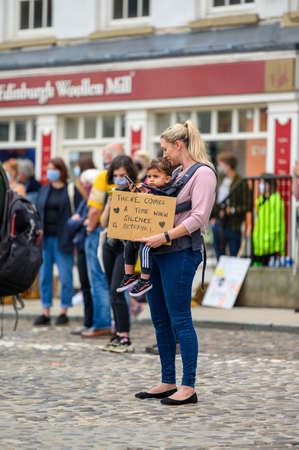 Richmond, North Yorkshire, UK - June 14, 2020: A mother holds a young child and a homemade sign at a Black Lives Matter protest in Richmond North Yorkshireのeditorial素材
