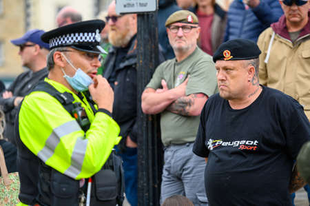 Richmond, North Yorkshire, UK - June 14, 2020: A Police Officer adjusts his PPE face mask and...