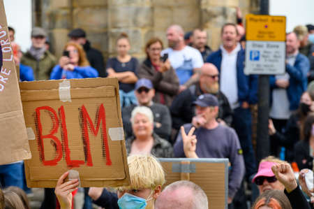 Richmond, North Yorkshire, UK - June 14, 2020: Homemade BLM sign with out of focus angry British Counter Protesters in the background at a Black Lives Matter protestのeditorial素材