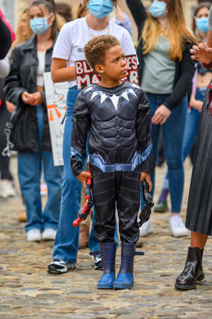Richmond, North Yorkshire, UK - June 14, 2020: A young Superhero at a Black Lives Matter protest with white protesters wearing PPE masks in the backgroundのeditorial素材