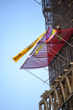 LONDON - OCTOBER 18, 2019: Vertical shot of Boris Johnson impersonator Extinction Rebellion Protester having climbed scaffold cladding on Houses of Parliament Big Ben Towerのeditorial素材