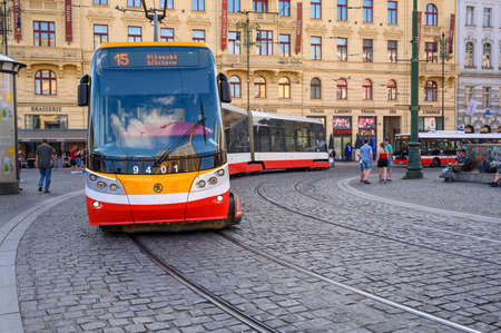 PRAGUE - JULY 20, 2019: A modern electric tram rounds a corner on the cobbled streets of the old town district of Pragueのeditorial素材
