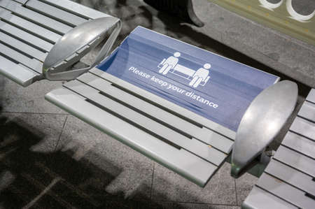 LONDON - SEPTEMBER 14, 2020: Social Distancing warning sign on a seat at King's Cross Railway Station during Covid 19 pandemicのeditorial素材
