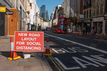 LONDON - SEPTEMBER 13, 2020: Social Distancing new road layout sign with London Double Decker Bus...