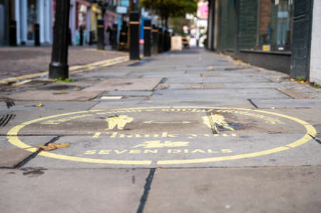 LONDON - NOVEMBER 3, 2020: Yellow Covid 19 social distancing sign painted on the ground in Covent Garden with a street out of focus in the backgroundのeditorial素材