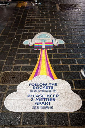 LONDON - NOVEMBER 1, 2020: A Covid 19 social distancing warning sign on the ground in China Town,...