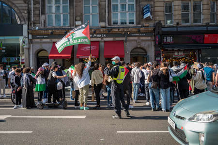 LONDON - MAY 29, 2021: British police officer wearing a PPE face mask at a Freedom for Palestine...