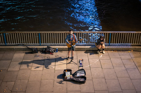 LONDON - SEPTEMBER 14, 2021: A busker singing and playing guitar on London's Southbank at nightのeditorial素材