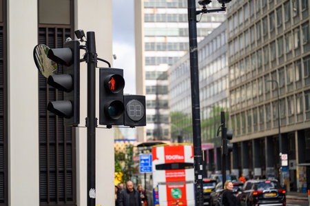 LONDON - May 20, 2022: Pedestrian crossing traffic lights above a busy London Street