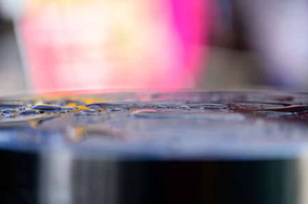 Abstract shallow focus close up shot of water drops reflecting colorful backgroundの写真素材