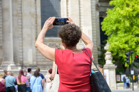 LONDON - May 21, 2022: Woman uses smartphone to take photograph of St Paul's Cathedral. Her photo is visible on the device screenのeditorial素材