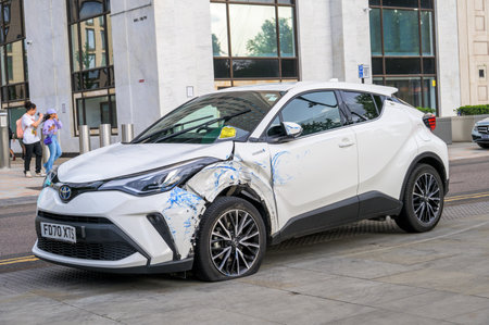 LONDON - May 21, 2022: Damaged white hybrid car at side of road on Southbank. Penalty Charge Notice parking fine attached to windscreenのeditorial素材