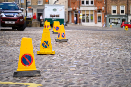 Richmond, North Yorkshire, UK - August 3, 2020: Yellow No Parking traffic cones laid out in the cobbled Richmond Market Placeのeditorial素材