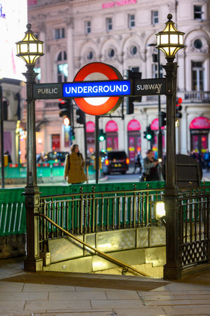 LONDON - November 3, 2020: London Underground Public Subway entrance to Piccadilly Tube Station illuminated at night with traffic out of focus in the backgroundのeditorial素材