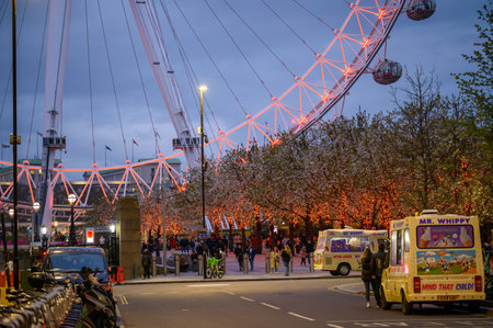 LONDON - April 22, 2023: Witness the poignant tribute on Stephen Lawrence Day as the London Eye illuminates orange, set against ice cream vans in the evening.のeditorial素材