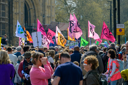 LONDON - April 22, 2023: Dynamic activism: Extinction Rebellion flags flutter high above the protest march in London, symbolizing the call for climate action.のeditorial素材