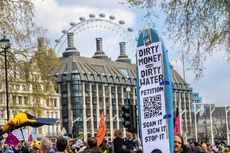 LONDON - April 22, 2023: Bridging tech and protest: A protest sign with a QR code becomes a gateway to XR's message at the London march, framed by the iconic London Eye.のeditorial素材